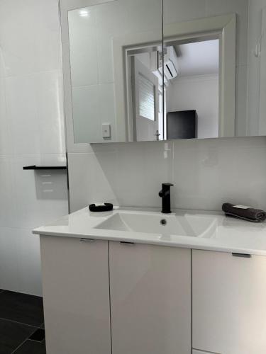 布罗肯希尔Away on Blende Studio Loft的白色的浴室设有水槽和镜子
