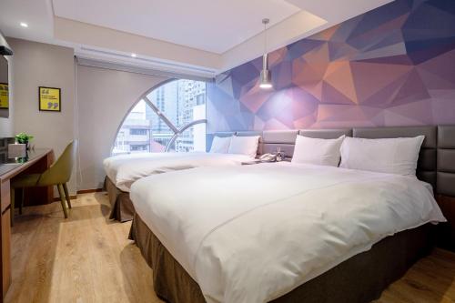 台中市雀客旅馆台中文心中清的配有几何墙的酒店客房内的两张床