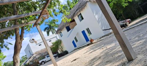 巴卡拉尔Posada Mykonos的一间拥有稻草屋顶的白色房子