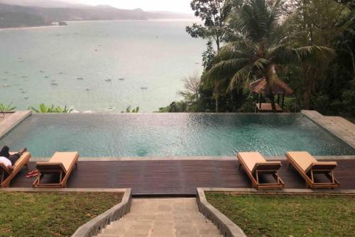 BantarkalapaTerrace Villa - Pelabuhan Ratu的一个带椅子的游泳池,享有水景