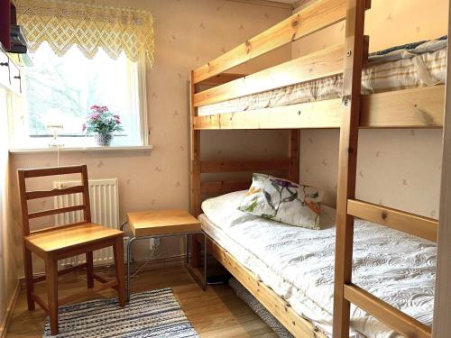 EckerudHoliday home PRÄSSEBO II的一间卧室配有两张双层床和椅子