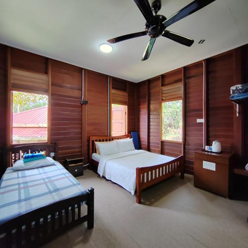 PedasD'Bukit Forest的一间卧室配有两张床和吊扇