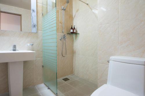 济州市Sims Hotel的带淋浴、卫生间和盥洗盆的浴室