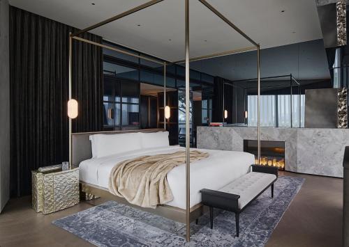 上海上海金普顿前滩酒店的一间卧室设有一张大床和一个壁炉