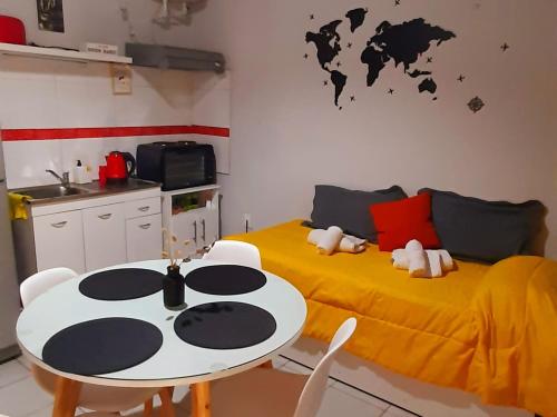 门多萨APART CENTRO RIOJA, Zona Residencial, Parking privado gratis a 100 mts的带两张床和一张桌子的房间以及一间厨房