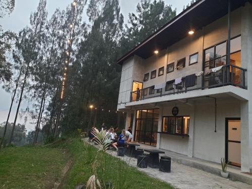 布罗莫Bromo Dormitory & Camp的坐在大楼外的长凳上的人