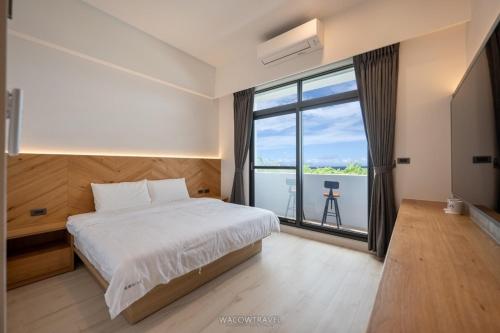小琉球岛觅曙  的一间卧室设有一张床和一个大窗户