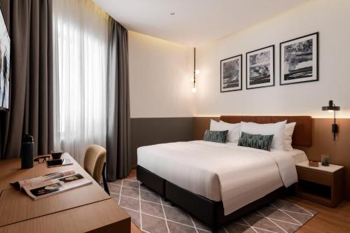 乔治市Citadines Connect Georgetown Penang的配有一张床和一张书桌的酒店客房