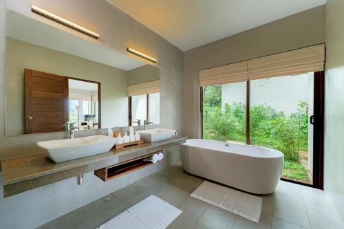 康提Celestial Hills - Villas & Suites by The Clarks的一间带两个盥洗盆的浴室和一个大窗户