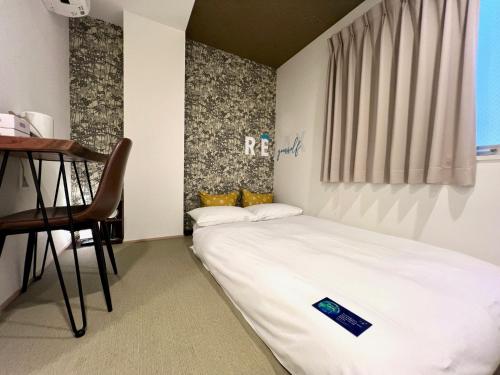 大阪HOTEL WAN OSAKA EBISU的一间小卧室,配有一张床和一把椅子
