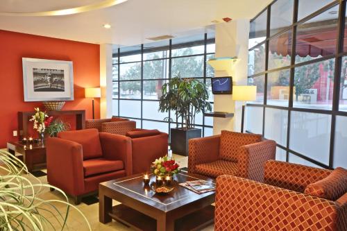 墨西哥城PF套房酒店的一间备有橙色椅子和桌子的等候室