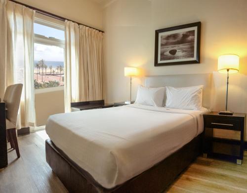 德班潘若迪酒店的一间设有大床和窗户的酒店客房