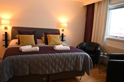 阿尔耶普卢格林克坦酒店的一间卧室配有一张床,上面有两条毛巾