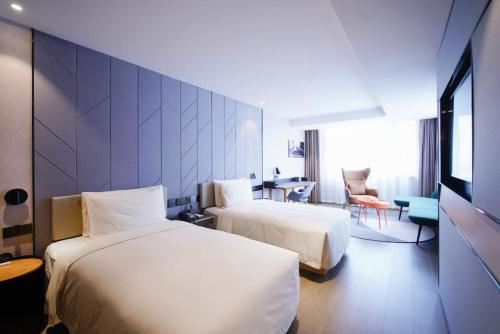 广州广州天河太古汇亚朵S酒店的酒店客房设有两张床和一张桌子。