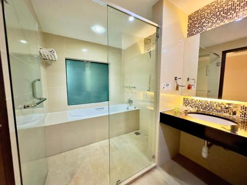 怡保近打河畔酒店与公寓的一间带玻璃淋浴和水槽的浴室