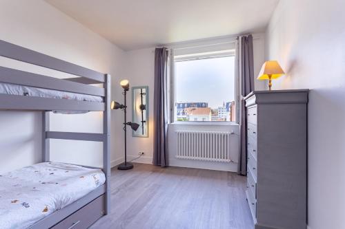 多维尔Le Carrousel - Appartement avec studio attenant的一间卧室配有双层床和窗户。