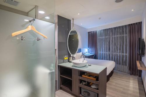 台北雀客旅馆台北信义的一间带水槽、镜子和淋浴的浴室