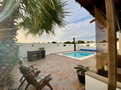 科斯塔特吉塞La Mar Poolvilla的一个带椅子的庭院和一个游泳池