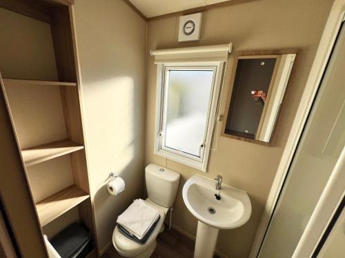 本布里奇2 Bedroom Caravan CW111, Whitecliff Bay, Bembridge, Isle of Wight的一间带卫生间和水槽的小浴室
