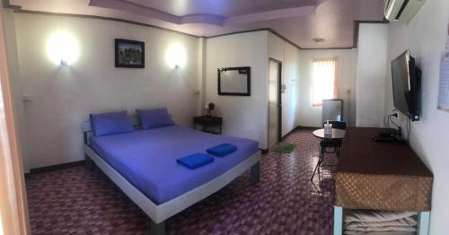 彭世洛วังอินธารา รีสอร์ท (Wangintara Resort)的一间卧室配有一张带蓝色枕头的大床