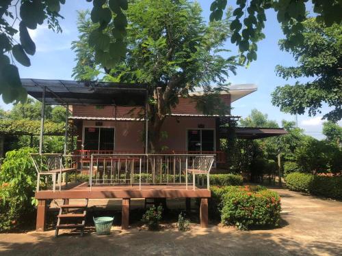 彭世洛วังอินธารา รีสอร์ท (Wangintara Resort)的一个小房子前面的长凳