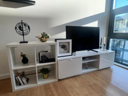 伦敦Luxury Modern Canary 1 bedroom Apartment的带平面电视的白色娱乐中心