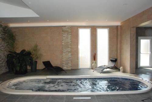 蓬托尔松法兰西酒店的一个带两把椅子的房间的大浴缸