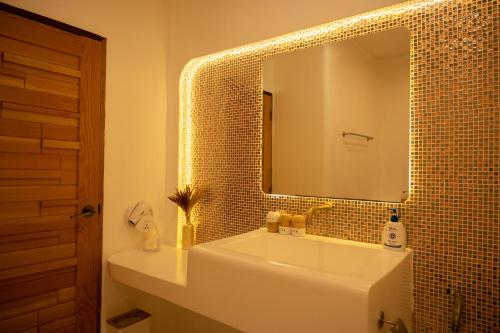 格兰岛Kamari Cafe&Resort Kohlarn คามารีคาเฟ่แอนด์รีสอร์ทเกาะล้าน的浴室设有白色水槽和镜子