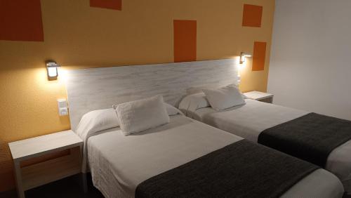 圣巴巴拉Hotel Venta de la Punta的酒店客房设有两张床和两盏灯。