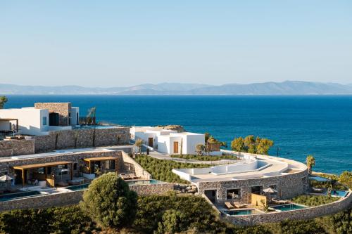 Ágios FokásKOIA All - Suite Well Being Resort - Adults Only的建筑的空中景观,背景是海洋