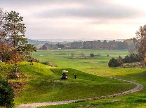 KodeKungälv-Kode Golf Club Apartments的高尔夫球场,果岭上带高尔夫球车