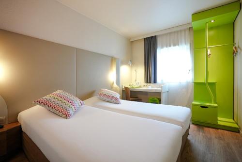 鲁瓦西昂法兰西Campanile Paris CDG Airport Villepinte的酒店客房设有两张床和盥洗盆