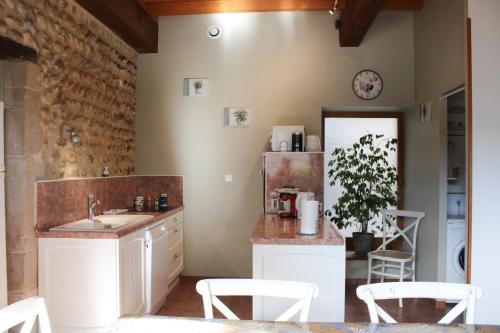 瓦朗斯堡热纳度假屋的厨房配有水槽和带椅子的柜台。