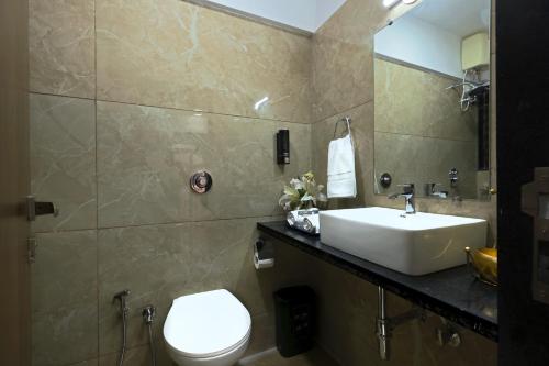 孟买Axon Aleta的一间带水槽、卫生间和镜子的浴室