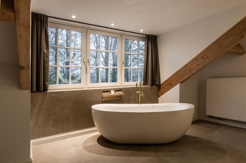 富伦Landgoed Altenbroek的带窗户的浴室内的白色大浴缸
