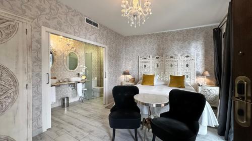 塞维利亚摩尔国王精品酒店的一间卧室配有一张床、一张桌子和两把椅子