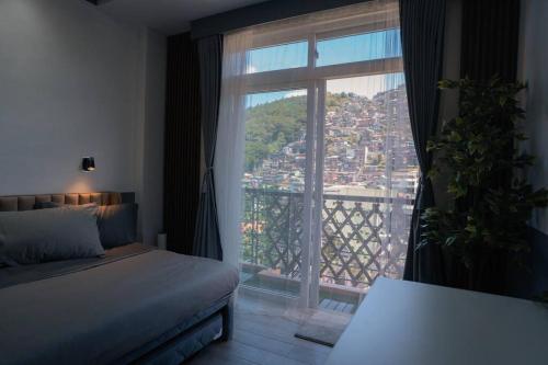 碧瑶Tinker's Cabin Baguio的一间卧室设有一张床和一个大窗户
