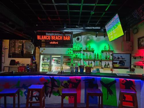 皮皮岛Blanco Beach Bar Hostel的一个带凳子的酒吧和一个绿灯的酒吧
