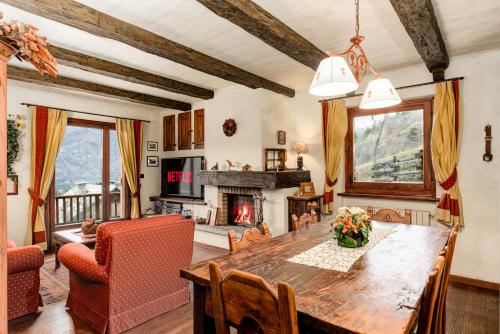 巴多尼奇亚5 min Piste Sci, Garage - Ski House Prerichard的一间带桌子和壁炉的用餐室