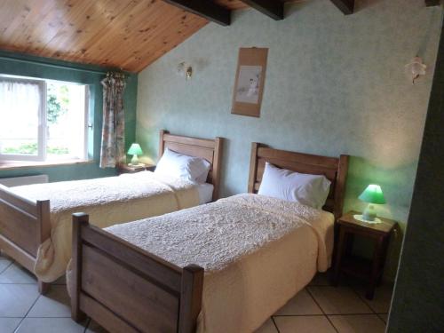 SolgneLes Chambres De Solgne的一间卧室设有两张床和窗户。