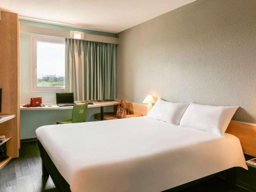 欧什宜必思奥赫酒店的酒店客房设有一张白色大床和一张书桌