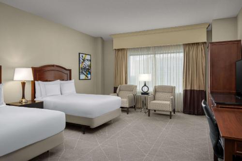 罗斯芒特芝加哥奥黑尔机场罗斯蒙特希尔顿逸林酒店的酒店客房设有两张床和电视。