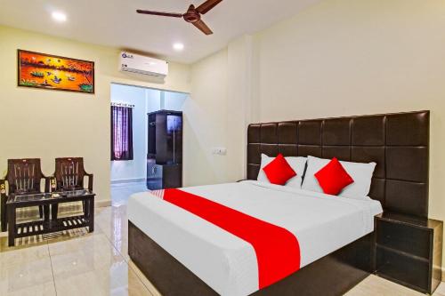 瓦朗加尔Lakshmi Royal Inn的一间卧室配有一张带红色枕头的大床