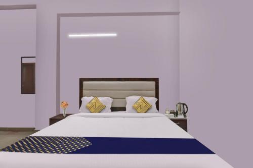 PratāpgarhSPOT ON Abhinandan Hotel And Restaurant的一间卧室配有一张带蓝色和黄色枕头的大床