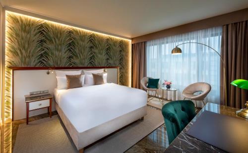 柏林JW Marriott Hotel Berlin的酒店客房带一张床铺、一张书桌和一间卧室