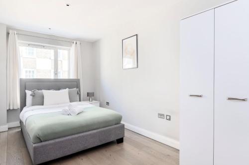 伦敦Westminster Abbey - CityApartmentStay的白色的卧室设有床和窗户