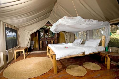姆托瓦姆布Migunga Tented Camp的帐篷内一间卧室,配有一张床