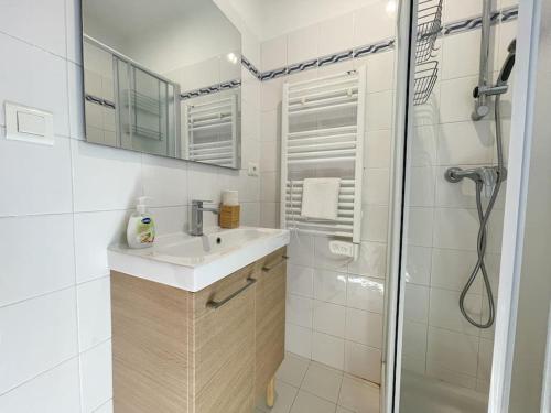 博索莱伊Le calmette的白色的浴室设有水槽和淋浴。