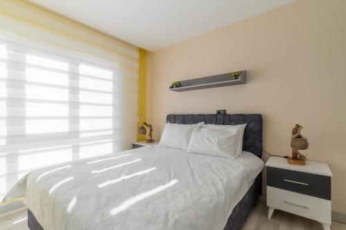 安塔利亚Comfy Residence Flat 3 min to Mall of Antalya的一间卧室设有一张大床和一个窗户。
