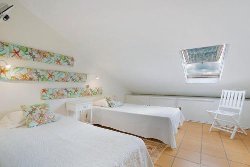 圣港Sun and Moon的客房设有两张床、一把椅子和窗户。